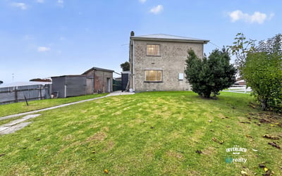 Spacious lot features a two-story home and versatile outbuilding, perfect for renovation or investment opportunities.