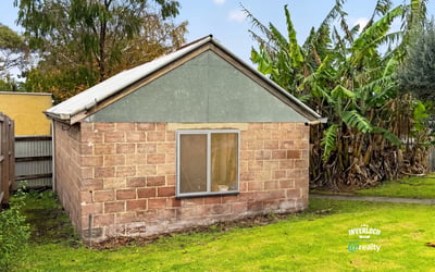 This property offers a unique renovation opportunity amid a spacious backyard surrounded by lush greenery.