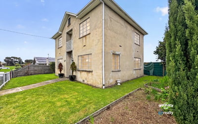 Spacious two-story home featuring a large yard and multiple windows for ample natural light.