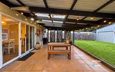 This inviting outdoor space features a spacious patio, perfect for gatherings and relaxation amidst landscaped surroundings.
