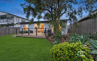 This cozy home features a welcoming deck and a spacious backyard, perfect for outdoor gatherings.