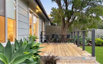 Discover a welcoming outdoor space featuring a spacious deck and lush greenery, perfect for relaxation.