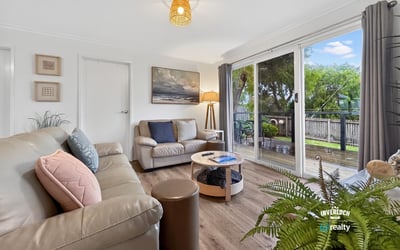 Bright living space featuring large windows that overlook a picturesque outdoor area, perfect for relaxation.