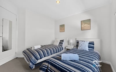 Bright and inviting twin bedroom featuring modern decor and comfortable furnishings for a relaxing stay.