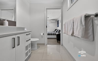 Modern bathroom featuring sleek cabinetry and contemporary finishes, seamlessly connecting to a cozy living area.