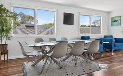 Bright and inviting dining area with large windows, modern furnishings, and beautiful wood flooring.