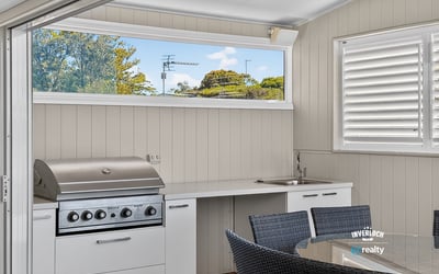 This outdoor entertaining space features a built-in grill and modern kitchen perfect for gatherings.