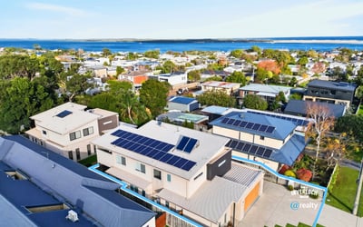 Modern home featuring solar panels and picturesque views, nestled in a vibrant coastal community.