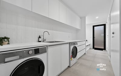 Modern laundry space featuring sleek cabinetry, high-efficiency appliances, and ample storage for convenience.