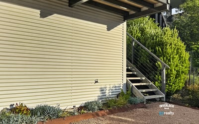 Modern exterior featuring a sleek design, landscaped garden, and convenient access via inviting stairs.