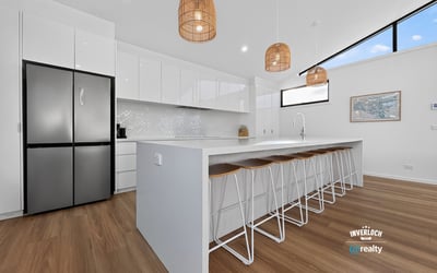 Modern kitchen featuring sleek cabinetry, a spacious island, natural light, and contemporary pendant lighting.