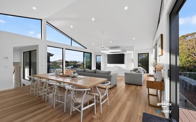 Bright, open living space features large windows, modern design, and seamless connectivity to outdoor views.