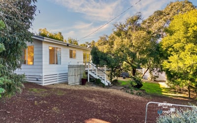 Well-maintained home nestled among lush greenery, featuring ample outdoor space and natural light throughout.
