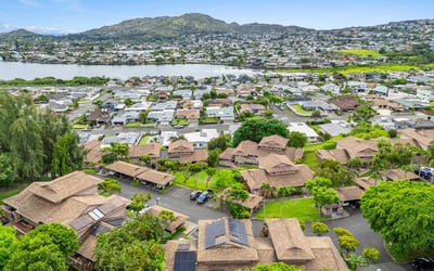 Stunning aerial view showcasing expansive waterfront and vibrant community nestled near picturesque mountain backdrops.