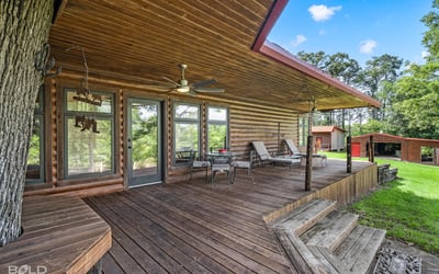 Spacious log home featuring a generous porch, ideal for outdoor living and relaxation surrounded by nature.
