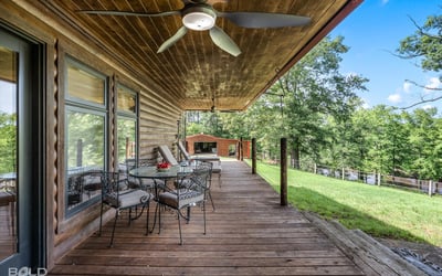 Spacious covered porch with ample seating, perfect for enjoying panoramic views of the surrounding landscape.