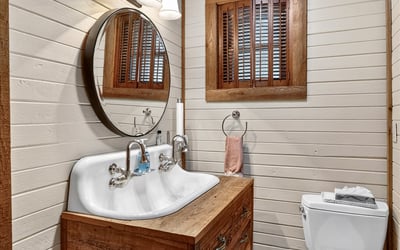 Cozy bathroom featuring a double sink vanity, natural wood accents, and soft lighting for a warm ambiance.