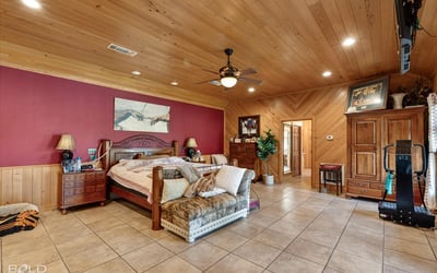 Spacious master bedroom featuring warm wood accents and ample natural light, perfect for relaxation and retreat.