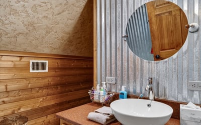 This unique bathroom features rustic wood accents and modern fixtures, creating a warm and inviting atmosphere.