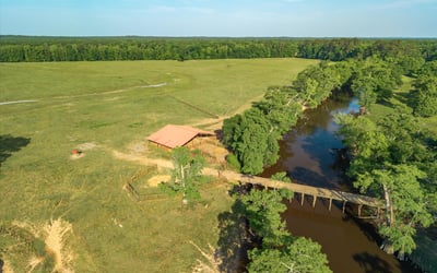 Spacious acreage with a scenic river and outbuilding, perfect for recreational or agricultural opportunities.