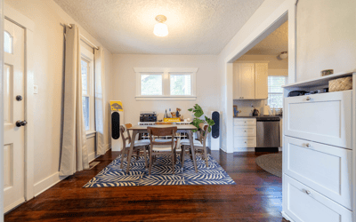 Bright and inviting dining area, featuring large windows and modern appliances, perfect for gatherings and everyday meals.