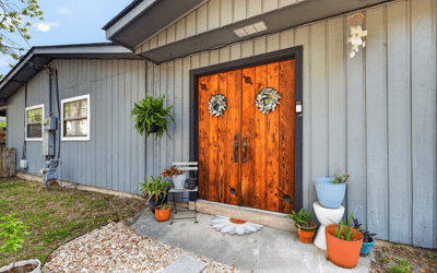 Inviting rear entryway featuring distinctive double doors and vibrant planters, perfect for welcoming guests home.
