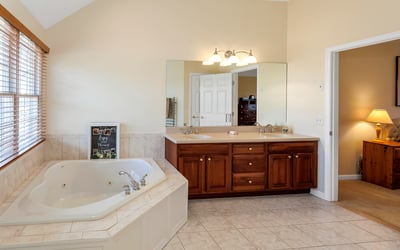 Luxurious Primary Bath with jetted tub, double vanity, and heated towel rack.