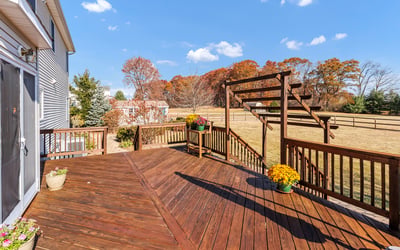 A paver walkway off the deck leads to the spacious fenced-in yard, paver patio, garden shed, and gate to the driveway.