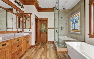 Enjoy spa-like comfort with a soaking tub, glass shower, dual sinks, and custom cabinetry creating a relaxing primary suite experience in this Phoenix home.