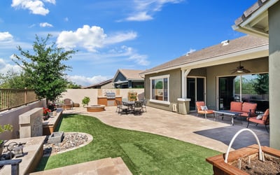 The covered patio and landscaped yard create an inviting outdoor extension of the home, perfect for entertaining, dining, or quiet evenings in Phoenix.