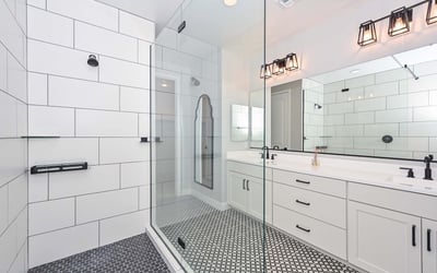 Indulge in the spa-like ambiance of this walk-in shower featuring oversized tile, matte black accents, and frameless glass. A standout upgrade in this Peoria residence.