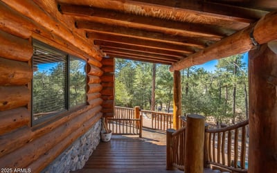 Shaded deck with log construction and wooded views, providing a quiet retreat surrounded by nature.