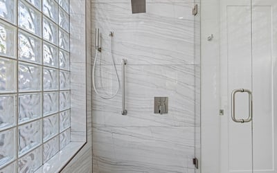 Large-format porcelain tiles add a polished, high-end finish to the updated bathroom design.