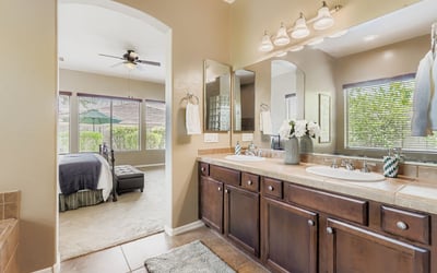 Double vanity with extensive cabinetry and updated mirrors ensures both convenience and elegance in the primary bath.