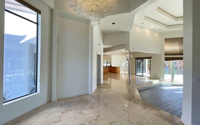 Dramatic entryway featuring a sparkling chandelier and open layout that flows effortlessly into the main living and kitchen spaces.