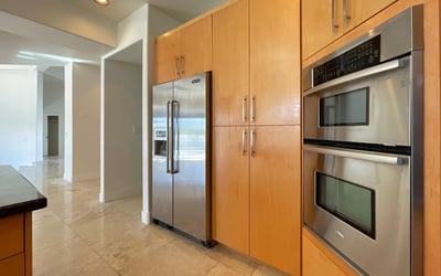 Sleek kitchen featuring premium stainless appliances and warm maple cabinetry combining efficiency with contemporary Scottsdale design.