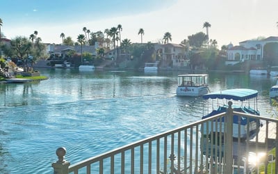 Waterfront view of calm blue waters surrounded by palm trees and luxury homes the ultimate lakeside lifestyle.