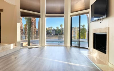 Modern fireplace surrounded by expansive windows and tranquil lake views. A peaceful retreat for both comfort and style.
