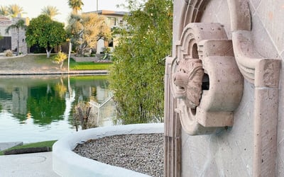Ornate stone lion fountain set beside the sparkling lake, creating a serene and elegant outdoor focal point.