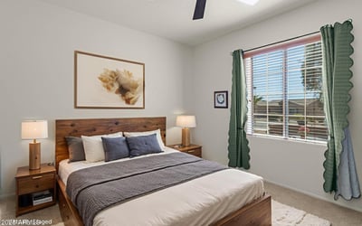 A cozy and bright guest bedroom offering plush carpeting, ceiling fan, and restful ambiance for visitors or everyday living.