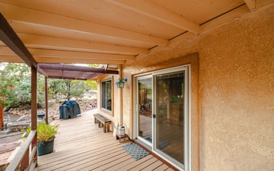 This covered porch area connects directly to the deck and backyard, creating a cool, sheltered space for outdoor living and year-round enjoyment.