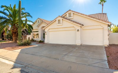 Spacious driveway leading to a three-car garage, offering convenient parking and storage options. The clean exterior lines and updated Scottsdale home design provide both functionality and visual appeal.
