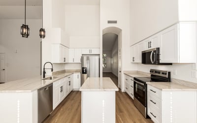 Beautiful center view of the remodeled Scottsdale kitchen showcasing clean cabinetry, stainless steel appliances, and a large center island. The open design makes this kitchen ideal for both cooking and entertaining.