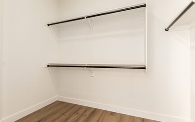 Generous walk-in closet with ample hanging rods and shelving for clothing storage. This Scottsdale closet provides convenient organization within the primary suite.