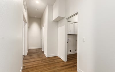 Bright hallway with updated flooring and neutral finishes connecting the living areas and bedrooms of this Scottsdale home. High ceilings and clean architectural lines enhance the spacious feel of the remodeled interior.