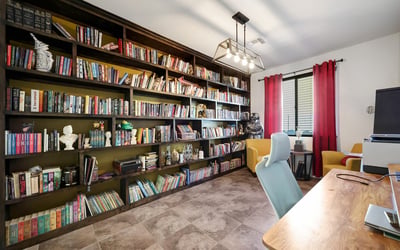 Versatile den featuring full wall built-in shelving and tile floors, ideal for working from home or personal hobbies.
