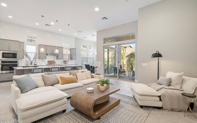 Open living room designed with comfort and flow in mind, featuring high ceilings, soft tones, and direct connection to the kitchen and dining spaces.