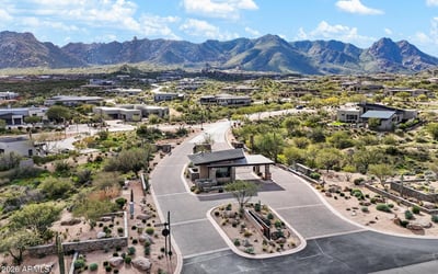 Twilight aerial view highlighting the illuminated guard house and professionally monitored entry to Sereno Canyon in North Scottsdale.