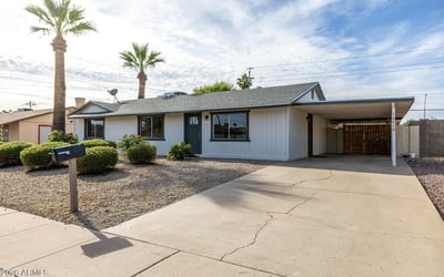 Convenient covered carport with a long driveway for easy parking, plus a clean exterior and desert landscaping showcasing everyday comfort and functionality in Phoenix.