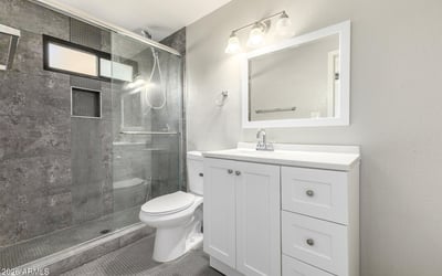 Updated bathroom featuring a walk-in shower with modern tilework, a fresh vanity, and clean finishes an excellent upgrade in this Phoenix home.